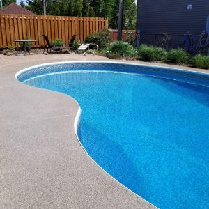 Revêtement en beton autour d’une piscine creusée